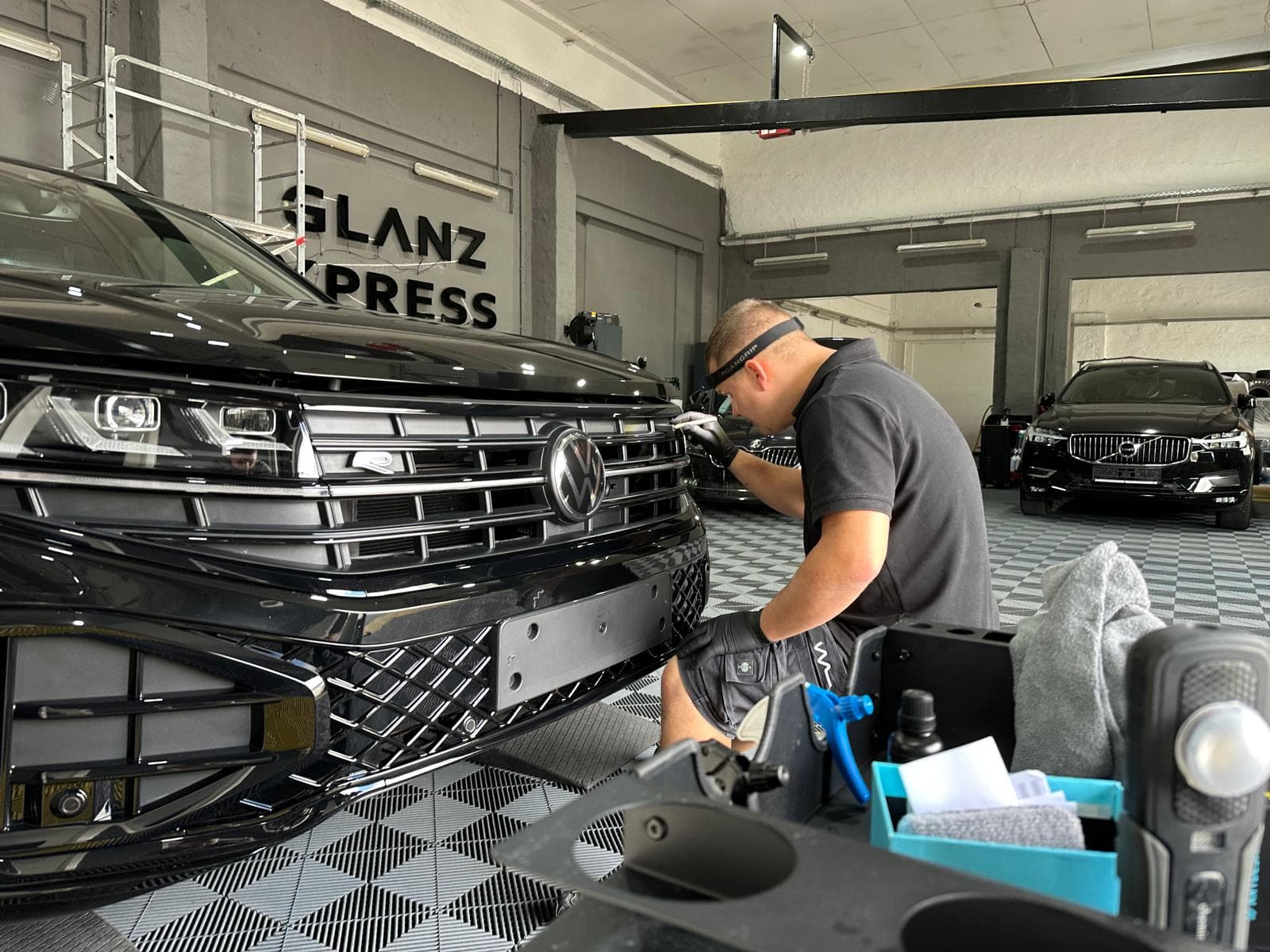 Mitarbeiter mit Stirnlampe an der VW-Front