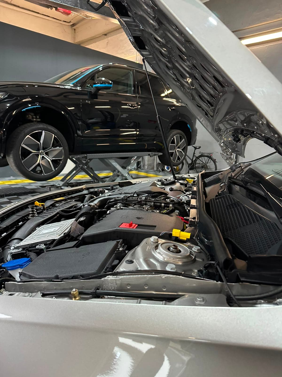 Motorraum eines silbernen Autos, Haube offen